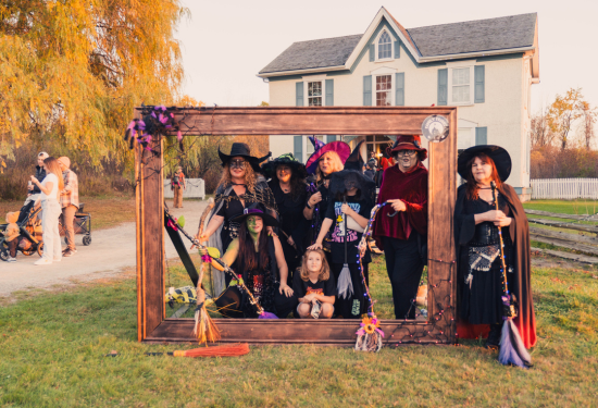 group of women dressed as witches standing within a wooden frame