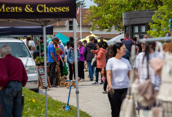 people walking among tents at a farmers market